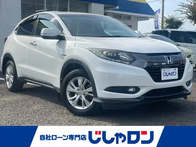 ホンダ ヴェゼル ハイブリッド X 徳島県 2014(平26)年 12.5万km ホワイトオーキッドパール (株)IDOMが運営する【じしゃロン徳島店】の自社ローン専用車両になりますこちらは現金またはオートローンご利用時の価格です。/自社ローンご希望の方は別途その旨お申付け下さい”										/社外ナビゲーション　/（フルセグ/CD/DVD/SD/BT)/衝突被害軽減ブレーキ　/バックモニター　/ＥＴＣ　/クルーズコントロール　/トラクションコントロール/スポーツモード切替/革巻きステアリング/電気式パーキングブレーキ/オートホールド/プッシュスタート　/スマートキー　/ＬＥＤヘッドライト　/フォグランプ/ウィンカーミラー/ステアリングリモコン/室内LEDランプ/カーテンエアバック　/純正フロアマット　/サイドバイザー