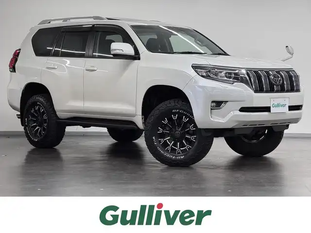 トヨタ ランドクルーザー プラド TX Lパッケージ 三重県 2020(令2)年 2万km ホワイトパールクリスタルシャイン ガソリン/パートタイム4WD/MTモード付フロア6AT/カロッツェリア 9インチ『楽ナビ』 AVIC-RQ902/（CD/DVD/MSV/SD/FM/AM/TV/Bluetooth/iPod/USB/HDMI/AUX）/バックカメラ/ビルトイン ETC/Toyota Safety Sense/・プリクラッシュセーフティ［PCS］/・レーンディパーチャーアラート［LDA］/・レーダークルコン/・オートハイビーム［AHB］/装備/・【OP】電動ムーンルーフ/・【OP】ルーフレール（ブラック）/・【OP】寒冷地仕様/・本革シート（ブラック）/・シートヒーター/ベンチレーション（D/N）/・パワーシート（D8way&ランバーサポート/N4way）/・オートライト/・LED ヘッドランプ＆フロント・リヤフォグランプ/・自動防眩インナーミラー/・雨滴感応式フロントワイパー/・17inAW＆BFグッドリッチ レタリングタイヤ/・プッシュスタート/・スマートキーx2/・保/取/ナビ取/など