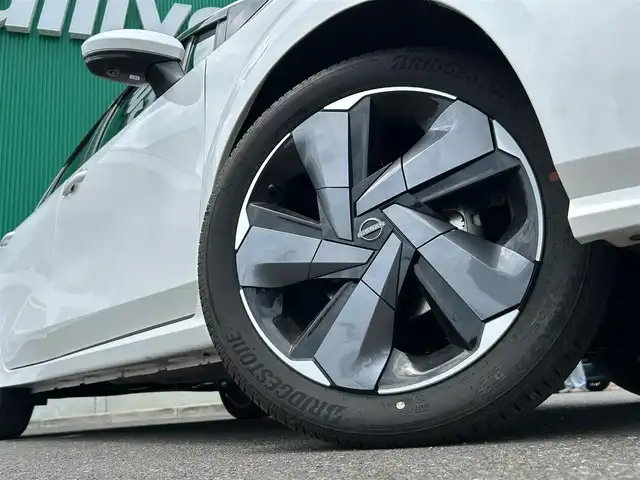 日産 オーラ G FOUR レザーエディション 宮城県 2024(令6)年 1.7万km ピュアホワイトパール 寒冷地仕様/・デアイサー/・LEDリアフォグランプ/コネクトナビゲーションシステム/・メモリーナビ/・9インチワイドディスプレイ/・地デジTV/・BOSEパーソナルプラスサウンドシステム/・USB電源ソケットタイプC(前席)/・ワイヤレス充電/・ETC2.0/・プロパイロット/・SOSコール/＝＝＝/4WD/インテリジェントエマージェンシーブレーキ/踏み間違い衝突防止アシスト/標識検知機能/前方衝突予測警報/車線逸脱警報/ふらつき警報/車線逸脱防止支援システム/エマージェンシーストップシグナル/後側方衝突防止支援システム/後側方車両検知警報/後退時車両検知機能/インテリジェントルームミラー/インテリジェントアラウンドビューモニター/純正ナビ/フルセグTV/Bluetooth/HDMI/USB/ドライブレコーダー/電動パーキングブレーキ/ブレーキホールド/本革シート/シートヒーター/ステアリングヒーター/アダプティブLEDヘッドランプ/フォグランプ/スマートキー/スペアキー有/純正17インチAW/純正フロアマット/取扱説明書/保証書