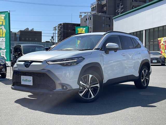 トヨタ カローラ クロス Z 長野県 2025(令7)年 0.8万km プラチナホワイトパールマイカ セーフティーセンス/・プリクラッシュセーフティ/・レーントレーシングアシスト/・レーンディパーチャーアラート/・レーダークルーズコントロール/・オートマチックハイビーム/・ロードサインアシスト/・ドライバー異常時対応システム/・発進遅れ告知機能/・パーキングサポートブレーキ/8インチディスプレイオーディオ/（BT/フルセグTV/AppleCarPlay/AndroidAuto）/バックカメラ/ビルトインETC/パワーバックドア/ハーフレザーシート/運転席パワーシート/前席シートヒーター/革巻きステアリング/ステアリングスイッチ/電動パーキングブレーキ/ブレーキホールド/LEDヘッドライト/LEDデイタイムランニングライト/フォグランプ/オートライト/スマートキー/Pスタート/電動格納ミラー/純正18インチAW