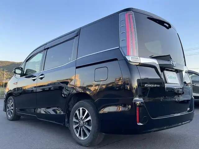 トヨタ エスクァイア ハイブリッド Gi プレミアムパッケージ ブラックテーラード 岡山県 2019(平31)年 9.2万km ブラック 登録時走行距離91610km/純正 10インチナビ NSZN-Z68T/（AM/FM/CD/DVD/TV/SD/SDREC/Bluetooth/USB）/純正 12.1インチ 後席フリップダウンモニター V12T-R68C/バックカメラ/両側パワースライドドア/ドライブレコーダー 前後/ビルトイン ETC/Toyota Safety Sense/・プリクラッシュセーフティ［PCS］/・レーンディパーチャーアラート［LDA］/・オートハイビーム［AHB］/・先行車発進告知機能/装備/・ハーフレザーシート/・快適温熱シート（D/N）/・ステアリングヒーター/・クルーズコントロール/・左右独立オートエアコン（S-FLOW：運転席集中機能付き）＋後席オートエアコン/・充電用USBジャック（前x2・2ndx2）/・オートライト/・LED ヘッドランプ＋フロントフォグランプ/・プッシュスタート/・自動防眩ルームミラー/・純正15inAW