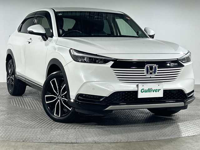 ホンダ ヴェゼル ハイブリッド e:HEV Z 神奈川県 2021(令3)年 2.7万km プラチナホワイトパール 無限グリル/ホンダコネクトディスプレイ/純正9型ワイドディスプレイオーディオ/インターナビ/プレミアムオーディオ/マルチビューカメラ/フルセグ　Bluetooth　USB/パワーバックドア/ホンダセンシング/ブラインドスポットインフォメーション/衝突軽減ブレーキ/誤発進抑制機能/後方誤発進抑制機能/近距離衝突軽減ブレーキ/歩行者事故低減ステアリング/路外逸脱抑制機能/アダブティブクルーズコントロール/車線維持支援システム/先行車発進お知らせ機能/標識認識機能/オートハイビーム/パーキングセンサー/ETC2.0/後退出庫サポート/ワイヤレス充電/革巻きステアリング/パドルシフト/ステアリングヒーター/ステアリングスイッチ/合皮/ファブリックコンビシート/前席シートヒーター/ECO/SPORTモード/電動パーキングブレーキ/AVH/プッシュスタート/スマートキー/LEDヘッドランプ/LEDフロントフォグランプ/LEDアクティブコーナリングランプ/LEDシーケンシャルターンランプ/純正18インチアルミホイール/純正リアスポイラー