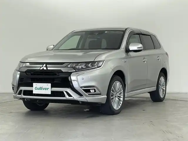 三菱 アウトランダー ＰＨＥＶ G 群馬県 2018(平30)年 1.9万km スターリングシルバーM 後側方車両検知警報システム/＝＝＝＝＝/7インチナビ/・AM/FM/CD/DVD/SD/Bluetooth/フルセグTV/マルチアラウンドモニター(バードアイビュー機能付)/e-Assist/・衝突被害軽減ブレーキシステム/・車線逸脱警報システム/・オートマチックハイビーム/・レーダークルーズコントロールシステム/パーキングセンサー/AC1500W/前席シートヒーター/ステアリングヒーター/ドライブレコーダー/電動パーキングブレーキ/オートブレーキホールド/プッシュスタート/スマートキー