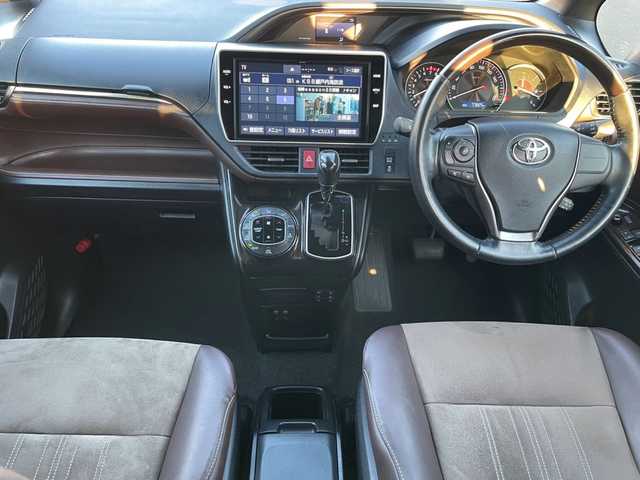 トヨタ エスクァイア Gi プレミアムパッケージ 岡山県 2019(令1)年 7.8万km ブラック 登録時走行距離 77825km/純正10インチナビ(NSZN-Z68T)/　(CD/DVD/フルセグTV/Bluetooth)/純正12.1インチフリップダウンモニター（V12T-R68C）/バックカメラ/衝突被害軽減システム/車線逸脱警報（レーンキープアシスト）/コーナーセンサー/ビルトインETC/両側パワースライドドア/ブラウンハーフレザーシート/シートヒーター（D・N席）/ステアリングヒーター/革巻きステアリング/ステアリングスイッチ/純正LEDヘッドライト/フォグライト/オートライト/オートマチックハイビーム/プッシュスタート/スマートキー/自動防眩式ルームミラー/MTモード付きAT/アイドリングストップ/純正アルミホイール 15インチ/ロールサンシェード/電動格納ミラー/オートリトラミラー/純正フロアマット車載/横滑防止装置/盗難防止装置/取扱説明書/新車時整備手帳（保証書）