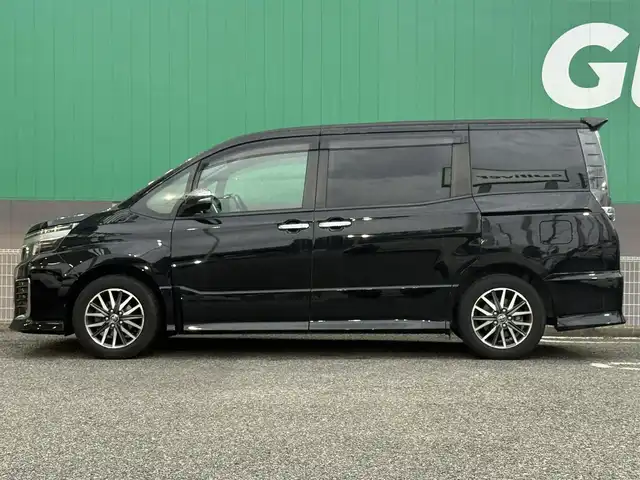 トヨタ ヴォクシー ZS 煌Ⅱ 千葉県 2016(平28)年 6万km ブラック 純正SDナビ/　(CD/DVD/SD/Bluetooth)/フルセグTV/バックカメラ/ALPINEフリップダウンモニター/前後ドライブレコーダー (DRV-MR480D)/ETC/ステアリングスイッチ/プリクラッシュセーフティ/レーンディパーチャーアラート/アイドリングストップ/プッシュエンジンスタート/スマートキー×2/両側パワースライドドア/リア席サイドサンシェード/オートライト/LEDヘッドライト/フォグランプ/ウィンカー付き電動格納ミラー/ドアバイザー/純正フロアマット/取扱説明書