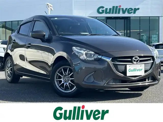 マツダ デミオ 13S 島根県 2015(平27)年 6万km チタニウムフラッシュマイカ 登録時走行距離59504km/純正ナビ（Bluetooth/AM/FM）/CD/DVDプレイヤー/地上デジタルTVチューナー(フルセグ)/バックカメラ/LEDヘッドランプ/オートライトシステム/フルオートエアコン/i-stop機能/ETC/ステアリングスイッチ/横滑り防止装置/衝突被害軽減ブレーキ/15インチ社外AW/ドアバイザー/プッシュスタート/スマートキー(スペアキー×1)