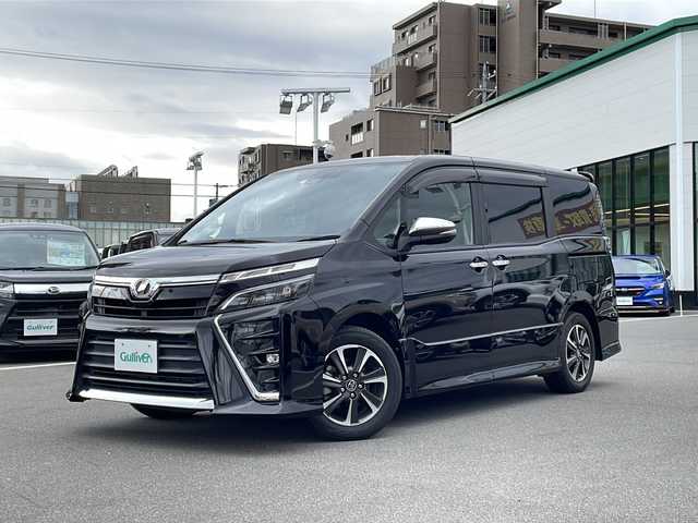 トヨタ ヴォクシー ZS 煌 長野県 2018(平30)年 5.7万km ブラック トヨタセーフティセンス/純正9インチSDナビ（NSZT-Y64T）/FM・AM・DVD・CD・フルセグテレビ・SD/Bluetooth Audio/バックカメラ/純正16インチアルミホイール/両側パワースライドドア/純正ドライブレコーダー/クルーズコントロール/アイドリングストップ/ロールサンシェード/革巻きステアリング/USB端子×２/純正フロアマット/LEDヘッドライト/オートライト/フォグランプ/プッシュスタート/スマートキー/ETC