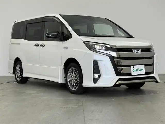 トヨタ ノア ハイブリッド Si 愛知県 2020(令2)年 1.9万km ホワイトパールクリスタルシャイン ディーラーオプション10インチTコネクトナビ/　　・Bluetooth対応/フルセグTV/HDMI/ドライブレコーダー/ビルトインETC/純正12.1インチ後席フリップダウンモニター/シートヒーター（前席）/キャプテンシート/社外ラバーマット/片側パワースライドドア（左側）/純正リヤスポイラー/純正16インチアルミホイール/LEDヘッドライト/社外ドアミラーガーニッシュ/クリアランスソナー/プリクラッシュセーフティ/クルーズコントロール/レーンキープアシスト/取扱説明書/保証書/スペアキー