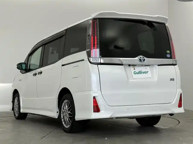 トヨタ ノア ハイブリッド Si 愛知県 2020(令2)年 1.9万km ホワイトパールクリスタルシャイン ディーラーオプション10インチTコネクトナビ/　　・Bluetooth対応/フルセグTV/HDMI/ドライブレコーダー/ビルトインETC/純正12.1インチ後席フリップダウンモニター/シートヒーター（前席）/キャプテンシート/社外ラバーマット/片側パワースライドドア（左側）/純正リヤスポイラー/純正16インチアルミホイール/LEDヘッドライト/社外ドアミラーガーニッシュ/クリアランスソナー/プリクラッシュセーフティ/クルーズコントロール/レーンキープアシスト/取扱説明書/保証書/スペアキー