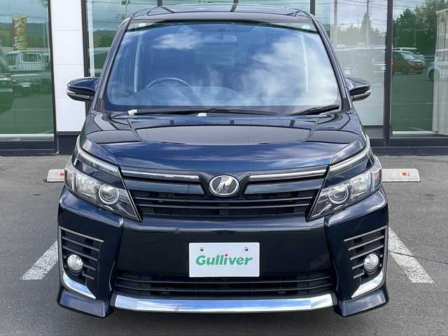 トヨタ ヴォクシー ZS 道東・釧路十勝 2014(平26)年 10.5万km ブラッキッシュアゲハガラスフレーク ・４WD/・寒冷地仕様/・MTモード付AT/・純正9インチSDナビ/（CD/DVD/BT/FM/AM/SD/フルセグ）/・バックカメラ/・ETC/・両側パワースライドドア/・アイドリングストップ/・フロントワイパーデアイサー/・電動格納ミラー/・サンシェード/・横滑り防止/・盗難防止/・LEDヘッドライト/・オートライト/・フォグランプ/・プッシュスタート/・スマートキー/・純正16インチアルミホイール