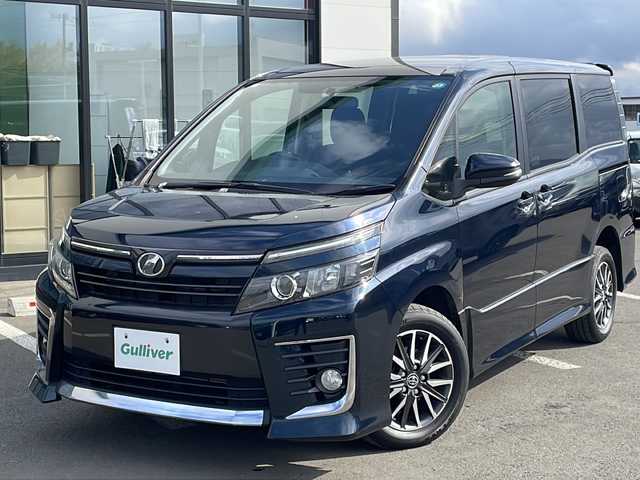 トヨタ ヴォクシー ZS 道東・釧路十勝 2014(平26)年 10.5万km ブラッキッシュアゲハガラスフレーク ・４WD/・寒冷地仕様/・MTモード付AT/・純正9インチSDナビ/（CD/DVD/BT/FM/AM/SD/フルセグ）/・バックカメラ/・ETC/・両側パワースライドドア/・アイドリングストップ/・フロントワイパーデアイサー/・電動格納ミラー/・サンシェード/・横滑り防止/・盗難防止/・LEDヘッドライト/・オートライト/・フォグランプ/・プッシュスタート/・スマートキー/・純正16インチアルミホイール