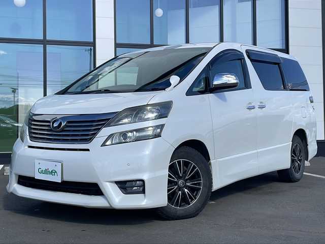 トヨタ ヴェルファイア 2．4Z プラチナセレⅡ ゴールド 道東・釧路十勝 2010(平22)年 12.2万km ホワイトパールクリスタルシャイン ・４WD/・寒冷地仕様/・純正ナビ（CD/DVD/TV/BT/SD/AM/FM）/・フルセグTV/・バックカメラ/・ETC/・両側パワースライドドア/・電動リアゲート/・純正フリップダウンモニター/・２列目オットマン/・前後コーナーセンサー/・横滑り防止装置/・フロントデアイサー/・プッシュスタート/・スマートキー×２/・社外エンジンスターター/・本革巻きステアリング/・木目調パネル/・電動格納ウィンカーミラー/・純正フロアマット/・ドアバイザー/・社外１６インチAW/・HIDヘッドライト/・フロントフォグランプ