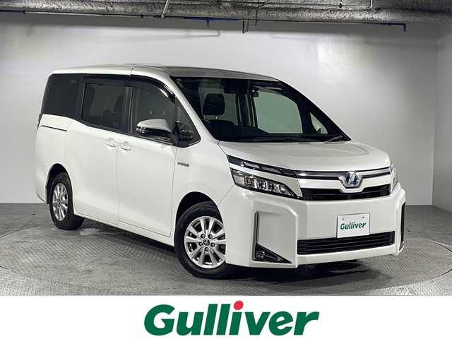 トヨタ ヴォクシー ハイブリッド X 沖縄県 2019(平31)年 6.1万km ホワイトパールクリスタルシャイン 禁煙車/県外仕入れ/９インチ純正ナビ/【CD/DVD/フルセグTV/BT】/バックカメラ/ETC/後席フリップダウンモニター/スマートキー/プッシュスタート/クルーズコントロール/前後ドライブレコーダー/ステアリングリモコン/両側パワースライドドア/衝突被害軽減システム/LEDヘッドライト/オートライト/スマートキー/スペアキー