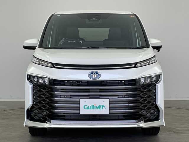 トヨタ ヴォクシー ハイブリッド S－Z 新潟県 2025(令7)年 0.1万km未満 ホワイトパールクリスタルシャイン 純正ディスプレイオーディオ/（BT/FM/AM/フルセグTV/DVD）/バックカメラ/ステアリングスイッチ/ステアリングヒーター/ハーフレザーシート/シートヒーター（1.2列目）/ワイパーデアイサー/AC100V/純正LEDオートヘッドライト/デジタルインナーミラー/電動リアゲート/両側パワースライドドア/サンシェード/電格ミラー/ウィンカーミラー/ヘッドライトレベライザー/ETC/取扱説明書/保証書