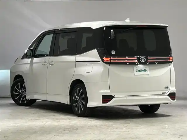 トヨタ ヴォクシー ハイブリッド S－Z 宮城県 2023(令5)年 6.5万km ホワイトパールクリスタルシャイン モデリスタシグネチャーイルミグリル/トヨタセーフティセンス/・プリクラッシュセーフティ/・レーンディパーチャーアラート/・プロアクティブドライビングアシスト/・パーキングサポートブレーキ/・クリアランスソナー/・ロードサインアシスト/・レーダークルーズコントロール/純正10.5インチディスプレイ/・ナビ/フルセグTV/BT/CD/DVD/HDMI/・バックカメラ/・ETC2.0/純正14型有機EL後席ディスプレイ/パワーバックドア/両側パワースライドドア/電子パーキング/・オートホールド/AC100V/革巻きステアリング/・ステアリングリモコン/・ステアリングヒーター/ハーフレザーシート/・シートヒーター(運転席/助手席/後席)/・オットマン/プッシュスタート/・スマートキー/・スペアキー/3眼LEDヘッドライト/・オートライト/・オートマチックハイビーム/電動格納ミラー/純正フロアマット/ドアバイザー
