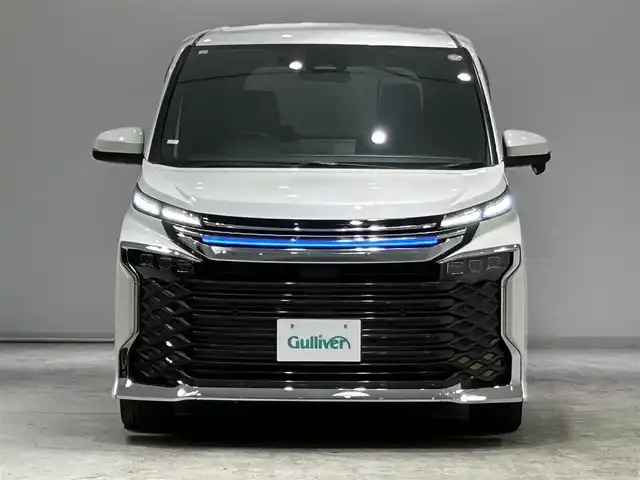 トヨタ ヴォクシー ハイブリッド S－Z 宮城県 2023(令5)年 6.5万km ホワイトパールクリスタルシャイン モデリスタシグネチャーイルミグリル/トヨタセーフティセンス/・プリクラッシュセーフティ/・レーンディパーチャーアラート/・プロアクティブドライビングアシスト/・パーキングサポートブレーキ/・クリアランスソナー/・ロードサインアシスト/・レーダークルーズコントロール/純正10.5インチディスプレイ/・ナビ/フルセグTV/BT/CD/DVD/HDMI/・バックカメラ/・ETC2.0/純正14型有機EL後席ディスプレイ/パワーバックドア/両側パワースライドドア/電子パーキング/・オートホールド/AC100V/革巻きステアリング/・ステアリングリモコン/・ステアリングヒーター/ハーフレザーシート/・シートヒーター(運転席/助手席/後席)/・オットマン/プッシュスタート/・スマートキー/・スペアキー/3眼LEDヘッドライト/・オートライト/・オートマチックハイビーム/電動格納ミラー/純正フロアマット/ドアバイザー