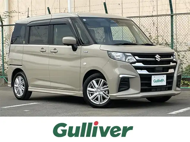 スズキ ソリオ HV MX 東京都 2025(令7)年 0.2万km キャラバンアイボリーPM ワンオーナー　/純正９型メモリナビ＆フルセグ　/・ＢｌｕｅｔｏｏｔｈＡｕｄｉｏ　/・ＡｐｐｌｅＣａｒＰｌａｙ/Ａｎｄｒｏｉｄ /・CD/DVD/AM/FM/両側パワースライドドア/アラウンドビューモニター/ セーフティサポート /（予防安全技術）/・デュアアルカメラブレーキサポート/・誤発進抑制機能/・後方誤発進抑制機能/・低速時ブレーキサポート/・パーキングセンサー/（フロント＆リア）/・車線逸脱抑制機能/・発進お知らせ機能/・車線逸脱抑制機能/・ふらつき警報/プッシュエンジンスタート/保証書＆取説