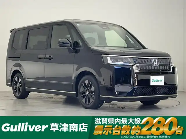 ホンダ ステップワゴン スパーダ eHEV 滋賀県 2025(令7)年 0.1千km クリスタルブラックパール 登録済未使用車/純正11.4インチナビ/【Bluetooth/CD/DVD/フルセグTV/Apple Carplay/Android Auto】/両側パワースライドドア/ハーフレザーシート/バックカメラ/ホンダセンシング/・衝突軽減ブレーキ/・先行車発進お知らせ機能/・歩行者事故低減ステアリング/・路外逸脱抑制機能/・標識認識機能/・渋滞追従機能付アダプティブクルーズコントロール/・車線維持支援システム/・トラフィックジャムアシスト（渋滞運転支援機能）/・ブラインドスポットインフォメーション/・誤発進抑制機能/・後方誤発進抑制機能/・近距離衝突軽減ブレーキ/・急アクセル抑制機能/・パーキングセンサーシステム/・オートハイビーム/・アダプティブドライビングビーム/LEDヘッドライト/パワーバックドア/D/Nシートヒーター/二列目オットマン/後席サンシェード/パドルシフト/プッシュスタート/スマートキー/ステアリングリモコン