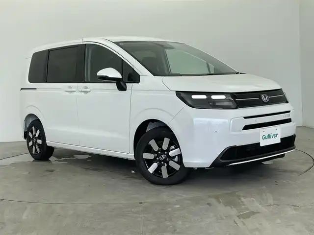 ホンダ フリード ハイブリット e:HEV AIR EX 富山県 2025(令7)年 0.1千km プラチナホワイトパール 登録済未使用車/4WD/純正9型ナビ（AM/FM/BT/USB/フルセグ）/バックカメラ/両側パワースライドドア/オートホールド付電子パーキング/ハーフレザーシート/シートヒーター/ブラインドスポットモニター/衝突被害軽減システム/レーダークルーズコントロール/レーンキープアシスト/コーナーセンサー/横滑り防止装置/純正アルミホイール/オートLEDライト/革巻きステアリング/ステアリングスイッチ