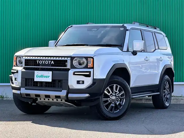 トヨタ ランドクルーザー ２５０ VX 宮城県 2025(令7)年 2.3万km プラチナホワイトパールマイカ 丸目1眼LEDヘッドライト/ルーフレール/モデリスタパッケージ/・フロントバンパーガード/・フロントアンダーカバー/・リヤバンパーガーニッシュ/モデリスタシグネチャーイルミブレード/ワンオーナー/純正12.3インチディスプレイオーディオナビ/・フルセグ/・HDMI入力/・パイオニアプレミアムサウンドシステム/・AppleCarPlay/ＡｎｄｒｏｉｄＡuto/・ＡＭ/FMチューナー/・ＵＳＢ入力/パノラマミックビューモニター/セーフティセンス/・プリクラッシュセーフティ/・レーダークルーズコントロール/・レーンディパーチャーアラート/・オートマチックハイビーム/・ドライバー異常検知対応システム/・プロアクティブドライビングアシスト/・発進遅れ告知機能/・レーントレーシングアシスト/・ロードサインアシスト/デジタルインナーミラー/ドライブレコーダー/黒革シート【ベンチレーション】/パワーシート/スペアタイヤ/保証書