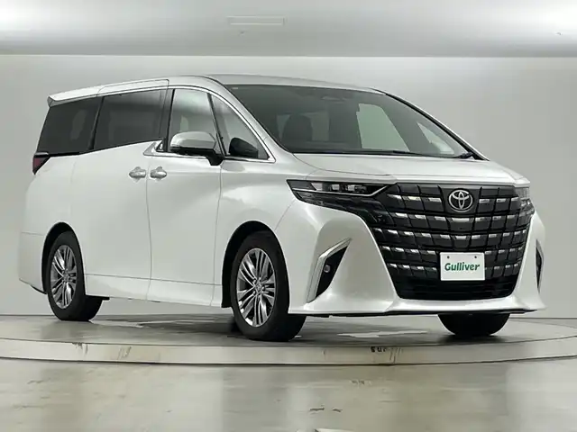 トヨタ アルファードハイブリット Z 愛知県 2024(令6)年 4.1万km プラチナホワイトパールマイカ 禁煙車/純正14インチナビ/（AM/FM/フルセグTV/Bluetooth/USB）/全方位カメラ/フリップダウンモニター/ワイヤレス充電/AC100V電源/デジタルインナーミラー/トヨタセーフティセンス/・プリクラッシュセーフティ/・レーダークルーズコントロール/・レーンディパーチャーアラート/・オートマチックハイビーム/ヘッドアップディスプレイ/ブラインドスポットモニター/ETC２．０/前後ドライブレコーダー/オットマン/パワーシート/シートベンチレーション/シートヒーター/両側パワースライドドア/パワーバックドア/電子パーキングブレーキ/オートホールド/純正アルミホイール/純正フロアマット/3眼式LEDヘッドライト/フロントフォグランプ/プッシュスタート/スマートキー/スペアキー有/横滑り防止装置/革巻きステアリング