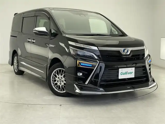 トヨタ ヴォクシー ハイブリッド ZS 煌 千葉県 2018(平30)年 5.7万km イナズマスパーキングブラックガラスフレーク モデリスタエアロ/衝突軽減ブレーキ/レーンキープアシスト/レーダークルーズコントロール/オートマチックハイビーム/純正メモリナビ/（フルセグ//Bluetooth/CD/DVD/USB/FM/AM/HDMI）/バックカメラ/ＥＴＣ/ドライブレコーダー（前のみ）/アイドリングストップ/シートヒーター（運転席＋助手席）/両側パワースライドドア/シートバックテーブル/LEDヘッドライト/フォグライト/電動格納ミラー/ロールサンシェード