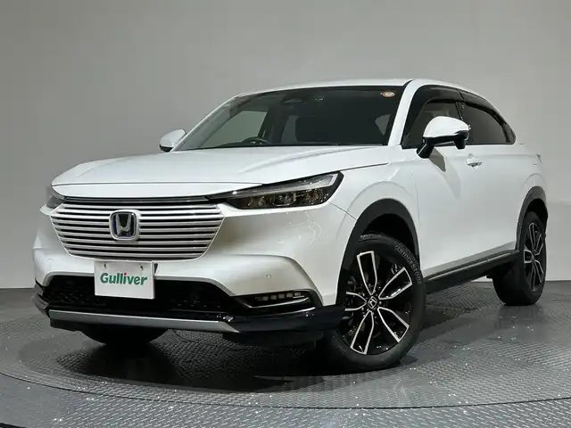 ホンダ ヴェゼル ハイブリッド e:HEV Z 愛媛県 2024(令6)年 2.6万km プラチナホワイトパール メーカーナビ/(Bluetooth/フルセグ)/バックカメラ/衝突被害軽減ブレーキ/レーンキープアシスト/前後コーナーセンサー/電動リアゲート/前後ドライブレコーダー/レーダークルーズコントロール/ダウンヒルアシストコントロール/ステアリングヒーター/シートヒーター/ETC2.0/ステアリングスイッチ/ワイヤレス充電/ブラインドスポットモニター/パドルシフト/LEDヘッドライト/オートマチックハイビーム/オートライト/トノカバー/ドアバイザー/スペアキー/保証書