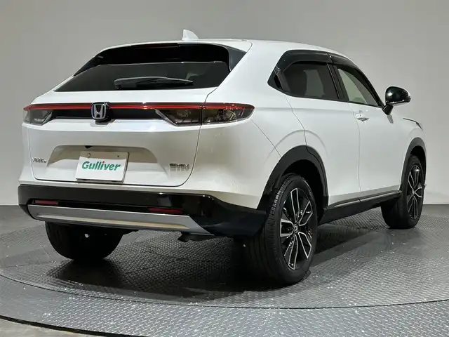 ホンダ ヴェゼル ハイブリッド e:HEV Z 愛媛県 2024(令6)年 2.6万km プラチナホワイトパール メーカーナビ/(Bluetooth/フルセグ)/バックカメラ/衝突被害軽減ブレーキ/レーンキープアシスト/前後コーナーセンサー/電動リアゲート/前後ドライブレコーダー/レーダークルーズコントロール/ダウンヒルアシストコントロール/ステアリングヒーター/シートヒーター/ETC2.0/ステアリングスイッチ/ワイヤレス充電/ブラインドスポットモニター/パドルシフト/LEDヘッドライト/オートマチックハイビーム/オートライト/トノカバー/ドアバイザー/スペアキー/保証書