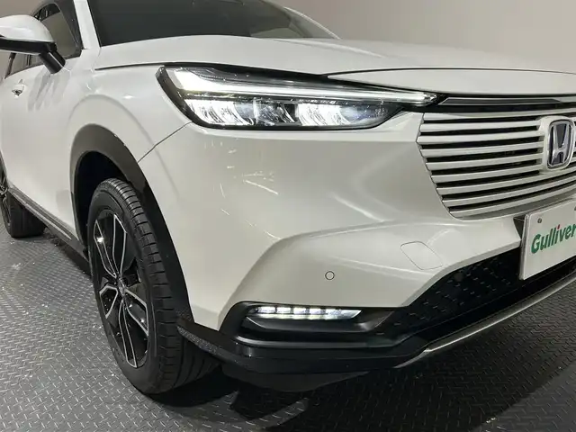 ホンダ ヴェゼル ハイブリッド e:HEV Z 愛媛県 2024(令6)年 2.6万km プラチナホワイトパール メーカーナビ/(Bluetooth/フルセグ)/バックカメラ/衝突被害軽減ブレーキ/レーンキープアシスト/前後コーナーセンサー/電動リアゲート/前後ドライブレコーダー/レーダークルーズコントロール/ダウンヒルアシストコントロール/ステアリングヒーター/シートヒーター/ETC2.0/ステアリングスイッチ/ワイヤレス充電/ブラインドスポットモニター/パドルシフト/LEDヘッドライト/オートマチックハイビーム/オートライト/トノカバー/ドアバイザー/スペアキー/保証書