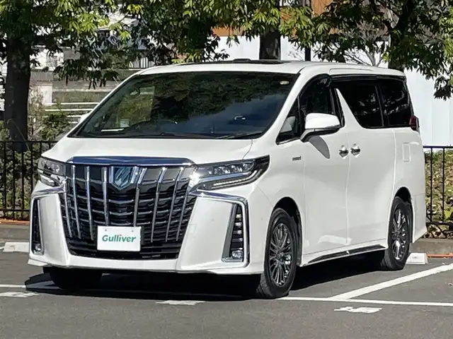 トヨタ アルファードハイブリット エグゼクティブ ラウンジ S 宮城県 2020(令2)年 4.1万km ホワイトパールクリスタルシャイン 4WD/ツインムーンルーフ/JBLサウンドシステム/トヨタセーフティセンス/・プリクラッシュセーフティ/・レーントレーシングアシスト/・クリアランスソナー/・パーキングサポートブレーキ/・ブラインドスポットモニター/・リヤクロストラフィックアラート/・ロードサインアシスト/純正ナビ/・フルセグTV/Bluetooth/CD/DVD/・純正フリップダウン/・純正ビルドインETC2.0/・ドライブレコーダー前方/・デジタルインナーミラー/・全方位カメラ/電子パーキング/・オートブレーキホールド/電動リアゲート/革巻きステアリング/・ステアリングスイッチ/レザーシート/・シートメモリー(運転席)/・シートヒーター（全席）/・オットマン（助手席・2列目）/AC100V充電/プッシュスタート/・スマートキー/LEDヘッドライト/・オートライト/・オートマチックハイビーム/・フォグランプ/純正アルミホイール/純正フロアマット/ドアバイザー