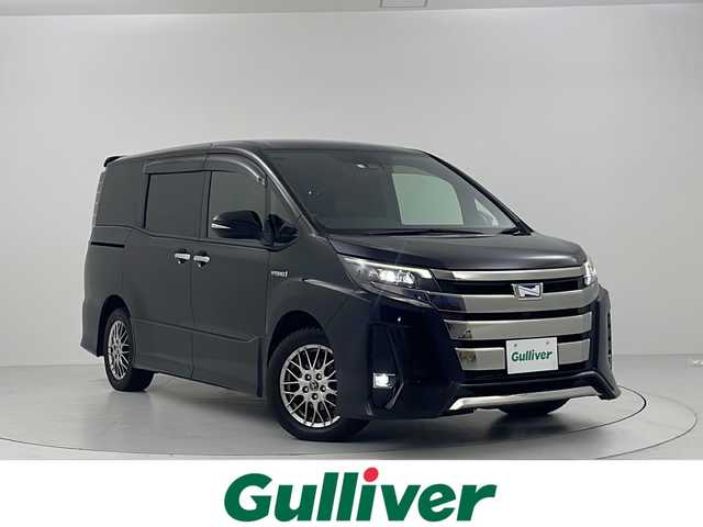 トヨタ ノア ハイブリッド Si ダブルバイビー 大阪府 2018(平30)年 5.6万km ブラック セーフティセンスC/　・先行車発進告知/　・プリクラッシュセーフティシステム/　・レーンディバーチャーアラート/　・オートマチックハイビーム/フリップダウンモニター/純正ナビ（Bluetooth/CD/DVD/AM/FM）/フルセグTV/バックカメラ/両側パワースライドドア/レーダークルーズコントロール/トラクションコントロール/2眼LEDヘッドランプ/フォグランプ/ハーフレザーシート/シートヒーター/プッシュスタート/スマートキー/ETC