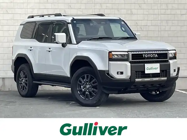 トヨタ ランドクルーザー ２５０ VX 愛知県 2024(令6)年 0.2万km プラチナホワイトパールマイカ 12.3インチ純正ディスプレイオーディオ（ナビ期限切れ）/Grgo ZVII カーセキュリティ/全方位カメラ/フルセグTV（キャンセラーあり）/ETC2.0/Bluetooth/USB/HDMI接続/MTモード付きAT/レーダークルーズコントロール/パワーシート（D/N）/3列シート/シートヒーター（D/N）/シートベンチレーション（D/N）/ステアリングヒーター/サンルーフ/純正フロアマット/パワーバックドア/純正18インチアルミホイール/LEDヘッドライト/オートマチックハイビーム/コーナーセンサー/横滑り防止装置/衝突軽減ブレーキ/レーンキープアシスト/ブラインドスポットモニター/電動パーキングブレーキ/ブレーキホールド/ルーフレール/ドライブレコーダー（前）/充電用Type-Cポート（6個）/パノラミックビューモニター/ヘッドライトウォッシャー