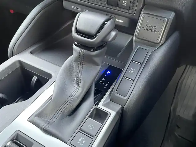 トヨタ ランドクルーザー ２５０ VX 愛知県 2024(令6)年 0.2万km プラチナホワイトパールマイカ 12.3インチ純正ディスプレイオーディオ（ナビ期限切れ）/Grgo ZVII カーセキュリティ/全方位カメラ/フルセグTV（キャンセラーあり）/ETC2.0/Bluetooth/USB/HDMI接続/MTモード付きAT/レーダークルーズコントロール/パワーシート（D/N）/3列シート/シートヒーター（D/N）/シートベンチレーション（D/N）/ステアリングヒーター/サンルーフ/純正フロアマット/パワーバックドア/純正18インチアルミホイール/LEDヘッドライト/オートマチックハイビーム/コーナーセンサー/横滑り防止装置/衝突軽減ブレーキ/レーンキープアシスト/ブラインドスポットモニター/電動パーキングブレーキ/ブレーキホールド/ルーフレール/ドライブレコーダー（前）/充電用Type-Cポート（6個）/パノラミックビューモニター/ヘッドライトウォッシャー