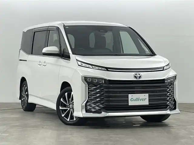 トヨタ ヴォクシー ハイブリッド S－Z 福島県 2024(令6)年 2.7万km ホワイトパールクリスタルシャイン セーフティセンス　/・プリクラッシュセーフティ　/・レーンディパーチャーアラート　/・レーントレーシングアシスト/・アダプティブハイビームシステム/・レーダークルーズコントロール　/・ロードサインアシスト/・ドライバー異常時対応システム/・プロアクティブドライビングアシスト/純正ナビゲーション/・Bluetooth/TV/CD/DVD/USB AM・FM/HDMI/applecarplay/androidauto/・バックカメラ/・ETC/ドライブレコーダー/両側パワースライドドア/革巻きステアリング/・ステアリングスイッチ/ハーフレザーシート/・シートヒーター/純正フロアマット/プッシュスタート/・スマートキー/ドアバイザー/電装格納ウィンカーミラー/電子パーキング/・オートホールド
