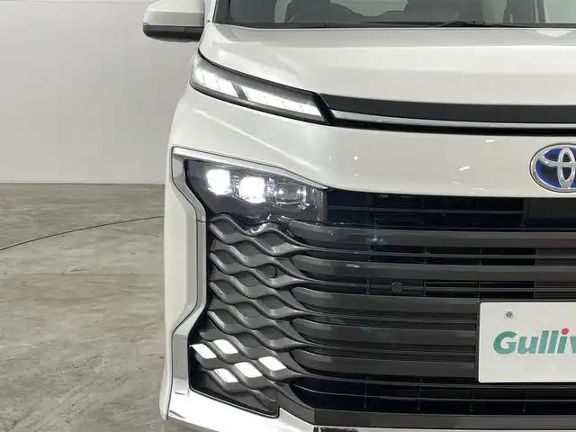 トヨタ ヴォクシー ハイブリッド S－Z 福島県 2024(令6)年 2.7万km ホワイトパールクリスタルシャイン セーフティセンス　/・プリクラッシュセーフティ　/・レーンディパーチャーアラート　/・レーントレーシングアシスト/・アダプティブハイビームシステム/・レーダークルーズコントロール　/・ロードサインアシスト/・ドライバー異常時対応システム/・プロアクティブドライビングアシスト/純正ナビゲーション/・Bluetooth/TV/CD/DVD/USB AM・FM/HDMI/applecarplay/androidauto/・バックカメラ/・ETC/ドライブレコーダー/両側パワースライドドア/革巻きステアリング/・ステアリングスイッチ/ハーフレザーシート/・シートヒーター/純正フロアマット/プッシュスタート/・スマートキー/ドアバイザー/電装格納ウィンカーミラー/電子パーキング/・オートホールド