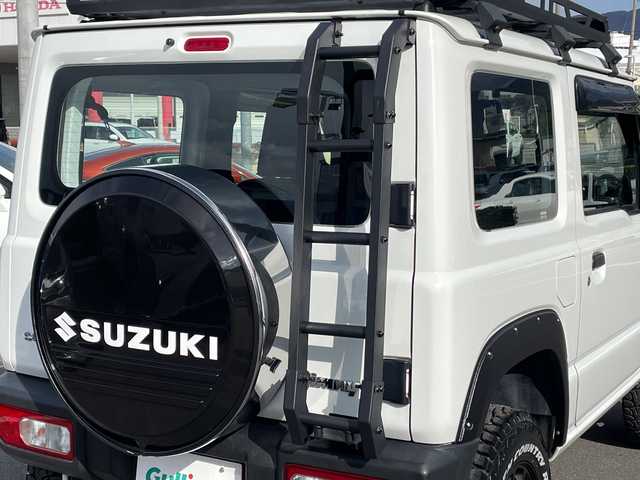 スズキ ジムニー XG 長野県 2023(令5)年 2.7万km スペリアホワイト 禁煙車/4WD/10インチフローティングマルチオーディオ/Bluetooth/社外スロットルコントローラー/グリルガード/オーバーフェンダー/背面タイヤカバー/1.5インチリフトアップキット/ルーフラック/リアラダー/純正足回り車載/ETC/純正アルミホイール/ダウンヒルアシスト/フォグランプ/LEDヘッドライト/オートライト/横滑り防止装置/ABS/ドアバイザー/リモコンキー/アイドリングストップ/パワーウインドウ/パワーステアリング/新車時保証書/取扱説明書