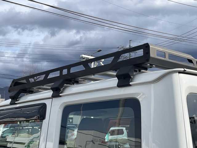 スズキ ジムニー XG 長野県 2023(令5)年 2.7万km スペリアホワイト 禁煙車/4WD/10インチフローティングマルチオーディオ/Bluetooth/社外スロットルコントローラー/グリルガード/オーバーフェンダー/背面タイヤカバー/1.5インチリフトアップキット/ルーフラック/リアラダー/純正足回り車載/ETC/純正アルミホイール/ダウンヒルアシスト/フォグランプ/LEDヘッドライト/オートライト/横滑り防止装置/ABS/ドアバイザー/リモコンキー/アイドリングストップ/パワーウインドウ/パワーステアリング/新車時保証書/取扱説明書