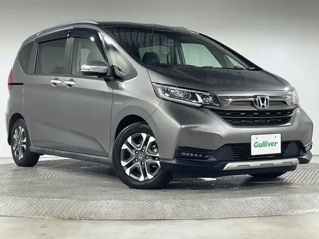 ホンダ フリード＋ ハイブリット クロスター ホンダセンシング 神奈川県 2020(令2)年 2.4万km スーパープラチナグレーメタリック 社外8インチナビ　(AVIC-RL811)/CD/DVD/FM/AM/フルセグTV/Bluetooth/iPod/バックカメラ　/両側パワースライドドア　/ホンダセンシング　/-CMBS　/-アダプティブクルーズコントロール　/-LKAS　/-路外逸脱抑制機能　/-誤発信抑制機能　/-先行車発進お知らせ機能　/-標識認識機能　/社外ドラレコ　/シルバールーフレール　/革巻きステアリング　/革巻きステアリング　/ステアリングスイッチ　/ETC　/ハーフレザー　