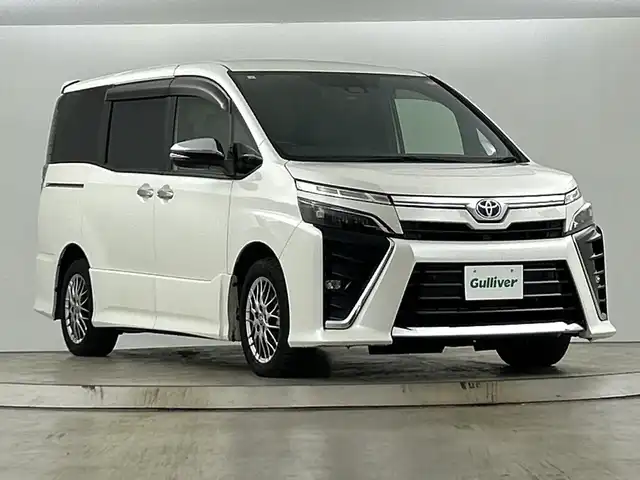 トヨタ ヴォクシー ハイブリッド ZS 煌Ⅲ 愛知県 2021(令3)年 5.8万km ホワイトパールクリスタルシャイン 禁煙車/純正10インチナビ/（CD/DVD/Bluetooth/フルセグTV/HDMI/SD)/バックカメラ/フリップダウンモニター/トヨタセーフティセンス/・プリクラッシュセーフティ/・レーンディパーチャーアラート/・オートマチックハイビーム/クルーズコントロール/ETC2.0/シートヒーター/両側パワースライドドア/純正16インチアルミホイール/LEDヘッドライト/フロントフォグランプ/オートライト/純正フロアマット/スマートキー/プッシュスタート/横滑り防止装置