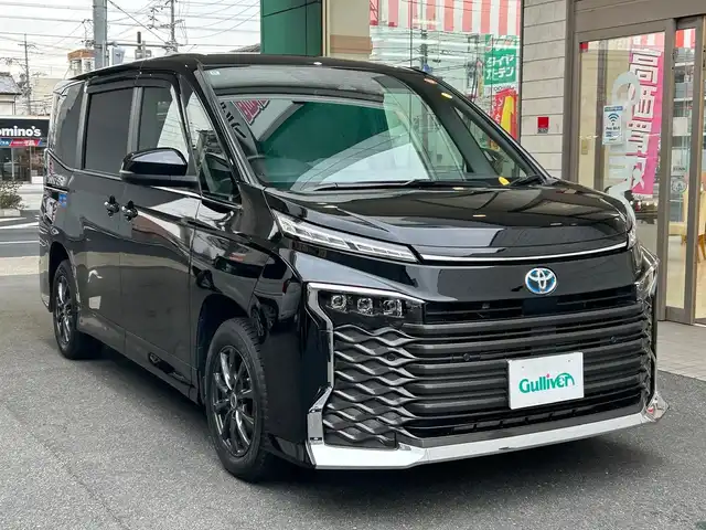 トヨタ ヴォクシー ハイブリッド S－Z 愛知県 2022(令4)年 4.9万km アティチュードブラックマイカ ワンオーナー/ディスプレイオーディオプラス〈MOP〉/・10.5インチディスプレイ／車載メモリナビ/・DVD／Bluetooth／地デジTV/・USB／HDMI／Apple Car Play／Android Auto/・ビルトインETC2.0/プロジェクター式LEDヘッドライト〈MOP〉/両側パワースライドドア/純正14.1型有機ELフリップダウンモニター/合皮＆ファブリックコンビシート/前席シートヒーター/2列目アームレスト付キャプテンシート/・充電用USBタイプC端子付折畳式サイドテーブル/社外16インチAW〈純正16インチAW積込〉/TOYOTA SAFETY SENSE/・プリクラッシュセーフティ/・レーントレーシングアシスト/・レーンディパーチャーアラート/・レーダークルーズコントロール/・オートマチックハイビーム/・ロードサインアシスト/・プロアクティブドライビングアシスト/ブラインドスポットモニター〈MOP〉/・安心降車アシスト/・アドバンスドドライブ/・フロントクロストラフィックアラート/・レーンチェンジアシスト/前後方パーキングサポートブレーキ/スマートキー