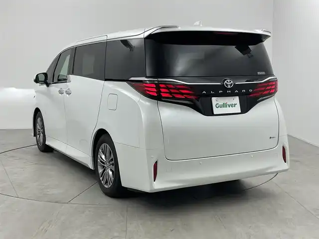 トヨタ アルファードハイブリット Z 愛知県 2024(令6)年 1.7万km プラチナホワイトパールマイカ 左右独立ムーンルーフ/13.2型有機EL後席ディスプレイ/14インチHDディスプレイオーディオ/(フルセグTV/BT/AM/FM)/合皮シート/前席＋二席目シートヒーター/前席＋二席目シートベンチレーション/全自動サンシェード/前後ドライブレコーダー/3眼LEDヘッドライト/ユニバーサルステップ/デジタルインナーミラー/トヨタセーフティセンス/・レーントレーシングアシスト/・プリクラッシュセーフティ/・ヘッドアップディスプレイ/・オートマチックハイビーム/・ブラインドスポットモニター/・クリアランスソナー/・パーキングサポートブレーキ/・アダクティブクルーズコントロール/ETC2.0/電動リアゲート/両側パワースライドドア/純正18インチAW/AC100V充電ソケット