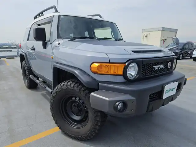 トヨタ ＦＪクルーザー 富山県 2012(平24)年 4.5万km セメントグレーM/ホワイト 〇ルーフレール/〇TRDスキッドプレート/〇TRUSTマフラー/〇4×4エンジニアリングショックアブソーバー/〇リフトアップ/〇社外9インチナビ/〇フルセグTV/〇背面タイヤ/〇リアラダー/〇ドライブレコーダー/〇純正17インチスチールホイール/〇マニュアルエアコン/〇ブラック撥水/防水ファブリックシート/〇リモコンキー/〇禁煙車