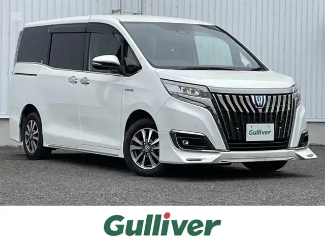 トヨタ エスクァイア ハイブリッド Gi プレミアムパッケージ 熊本県 2019(令1)年 3.9万km ホワイトパールクリスタルシャイン 純正９型ナビ/・AM/FM/CD/DVD/SD/BT/：フルセグTV/・バックカメラ/トヨタセーフティセンス/・プリクラッシュセーフティ/・レーンディパーチャアラート/・オートマチックハイビーム/・クリアランスソナー/クルーズコントロール/ウッドコンビステアリング/・ステアリングリモコン/・ステアリングヒーター/両側電動ドア/ビルトインＥＴＣ/ハーフレザーシート/・D/Nシートヒーター/前後ドライブレコーダー/LEDヘッドライト/オートライト/フォグランプ/スマートキー/スペアキー/プッシュスタート/純正フロアマット/純正ドアバイザー/純正15インチアルミホイール