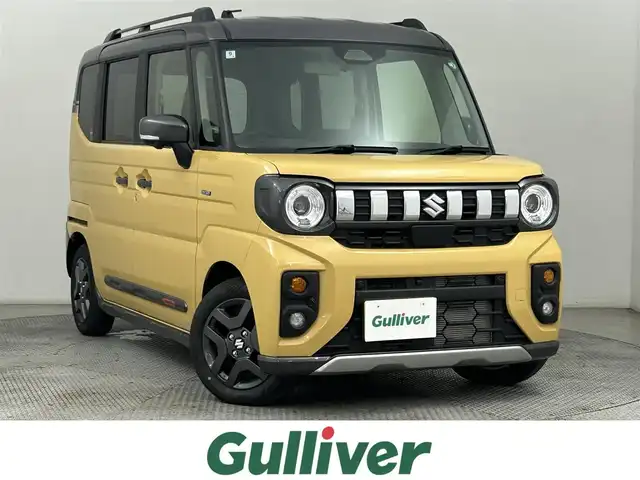スズキ スペーシア ギア HYBRID XZターボ 道央・札幌 2024(令6)年 0.2万km 黄Ⅱ ・４WD/・純正メモリーナビゲーション/　BT/USB/フルセグ/iPod/HDMI/・全方位カメラ/・ヘッドアップディスプレイ/・両側パワースライドドア/・レーダークルーズコントロール/・レーンキープアシスト/・衝突軽減ブレーキ/・横滑り防止装置/・前席シートヒーター/・ステアリングヒーター/・オートライト/・LEDヘッドライト/・フロントフォグランプ/・前後コーナーセンサー/・パドルシフト/・スマートキー/・プッシュスタート/・純正フロアマット/・純正ＡＷ14インチ/・ヘッドライトレベライザー/・シーバックテーブル/・ルーフファン