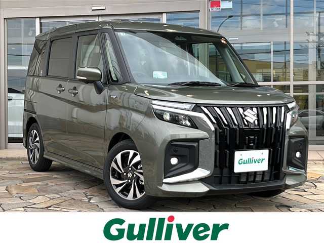 スズキ ソリオ バンディット HV MV 静岡県 2025(令7)年 0.1万km タフカーキパールメタリック 純正ナビ/・CD/DVD/USB/ipod/HDMI/Bluetooth/・apple Carplay/Android Auto/・ラジオ/フルセグTV/主要装備/・レーダークルーズコントロール　/・バックカメラ　/・ＢＳＭ　/・両側パワースライドドア　/・シートヒーター　/・ステアリングリモコン　/・レーンキープアシスト　/・オートライト　/・オートハイビーム　/・アイドリングストップ/・プッシュスタート/・スマートキー/・衝突軽減システム/・横滑り防止/・ヘッドアップディスプレイ/・サイドカメラ/・純正アルミホイール/・コーナーセンサー/・SOSコール/・フォグランプ