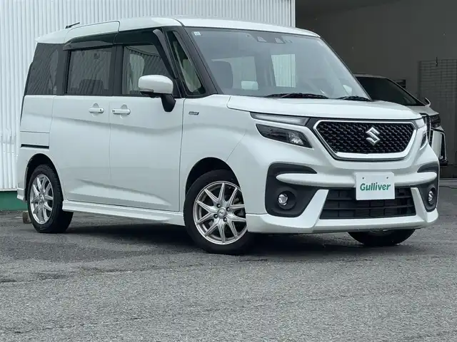 スズキ ソリオ バンディット HV MV 徳島県 2023(令5)年 2.7万km ピュアホワイトP 純正ナビ・フルセグＴＶ・ＣＤ・DVD再生・Bluetooth・USB接続・AMFMチューナー/衝突被害軽減システム/コーナーセンサー/車線逸脱警報装置/前席シートヒーター/プッシュスタート・スマートキー/社外15インチアルミホイール/LEDヘッドライト・フォグランプ/ダブル・サイドエアバック/純正フロアマット/ウィンカーミラー