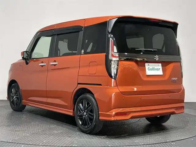 スズキ ソリオ HV SZ 愛媛県 2023(令5)年 1.3万km フレイムオレンジPM ・１０型ナビ/（フルセグＴＶ・ＢＴ・ＣＤ・ＤＶＤ・ＳＤ・ＦＭ・ＡＭ・ＵＳＢ）/・全方位カメラ　/・前後ドラレコ　/・両側パワースライドドア　/・ＤＮ席シートヒーター　/・ＵＳＢ充電　/・レーダークルーズコントロール/・レーンキープアシスト/・ヘッドアップディスプレイ/・サーキュレーター