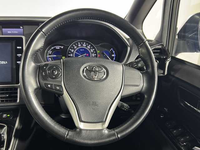 トヨタ ヴォクシー ハイブリッド ZS 煌 沖縄県 2018(平30)年 5.6万km イナズマスパーキングブラックガラスフレーク 禁煙車/県外仕入/7人乗り/純正10インチナビ/（フルセグTV/bluetooth/DVD/CD）/12.1インチフリップダウンモニター/前後ドライブレコーダー/モデリスタエアロ/フロントスポイラー/スタイリッシュモール/リアスカート/シグネチャーイルミブレード/トヨタセーフティセンス/プリクラッシュセーフティ/レーンディパーチャーアラート/オートマチックハイビーム/両側パワースライドドア/前席シートヒーター/ビルトインETC/純正フロアマット