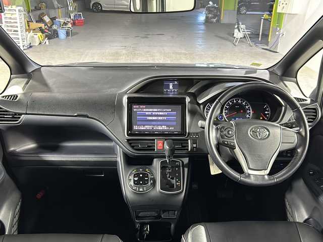 トヨタ ヴォクシー ZS 煌 沖縄県 2015(平27)年 8.4万km アイスチタニウムマイカメタリック 県外仕入　/純正９インチナビ/フルセグTV，Bluetooth，ラジオ，ＣＤ，ＤＶＤ　/７人乗り　/両側パワースライドドア/アルパインフリップダウン　/レザー調シートカバー　/ビルトインＥＴＣ　/ドライブレコーダー　/ライト付きハンディーミラー/デュアルエアコン/革巻きステアリング/純正ドアバイザー　/フロアマット/オートライト/LEDヘッドライト/フォグランプ/スペアキー/プッシュスタート