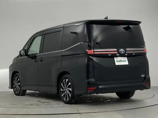 トヨタ ヴォクシー ハイブリッド S－Z 熊本県 2023(令5)年 2.9万km グリッターブラックガラスフレーク 純正10.5インチナビ/CD/DVD/フルセグTV/Bluetooth/純正14インチフリップダウンモニター/両側パワースライドドア/トヨタセーフティセンス/プリクラッシュセーフティ/レーンディパーチャーアラート/クリアランスソナー/パーキングサポートブレーキ/ロードサインアシスト/プロアクティブドライビングアシスト/快適利便パッケージ/ユニバーサルステップ/ハーフレザーシート/シートヒーター/オットマン/１００V充電/追従付きクルーズコントロール/オートハイビーム/前後ドライブレコーダー/ビルトインETC2.0/フロアマット/純正ドアバイザー/純正17インチアルミホイール